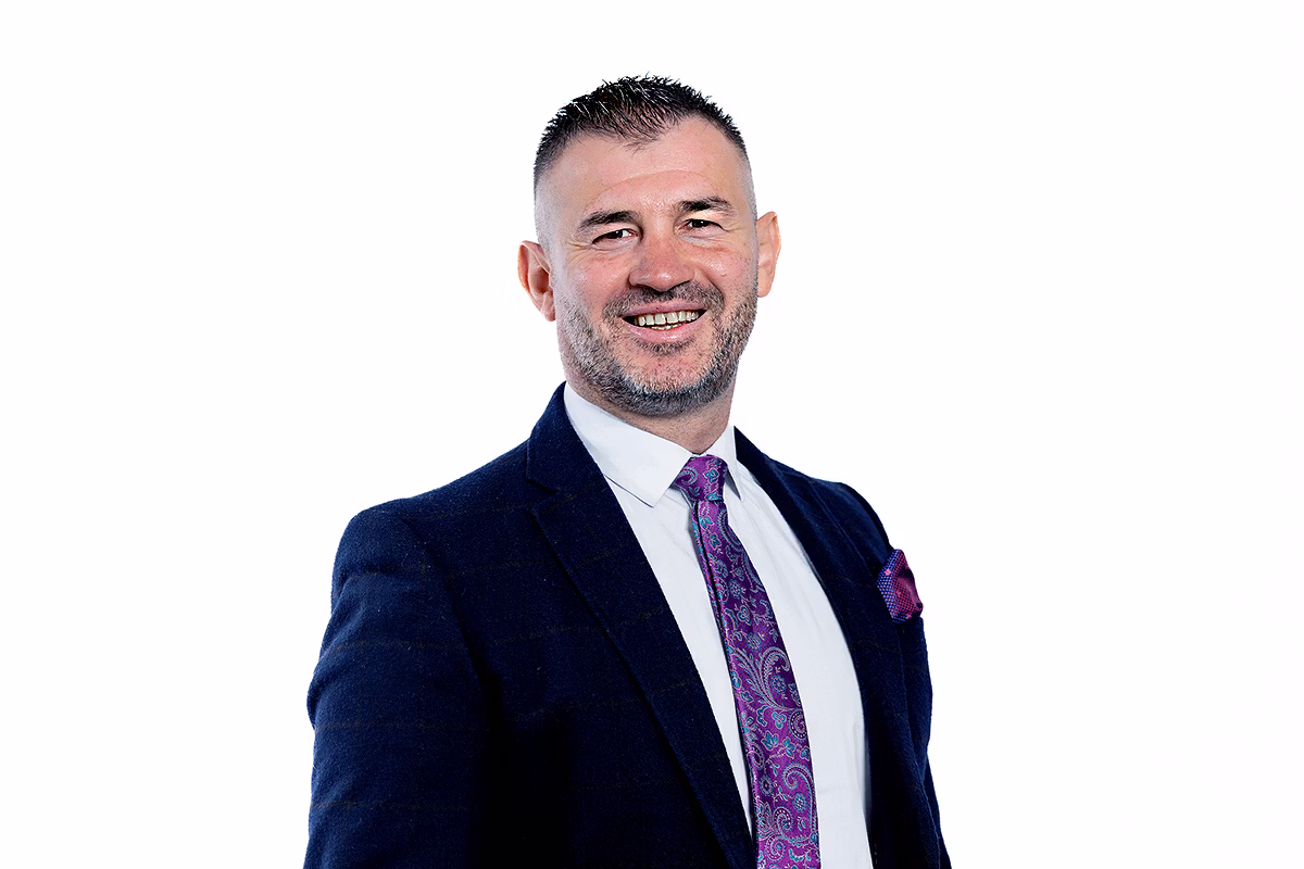 Corporate headshot photographer delivering a leadership team portrait with natural expression